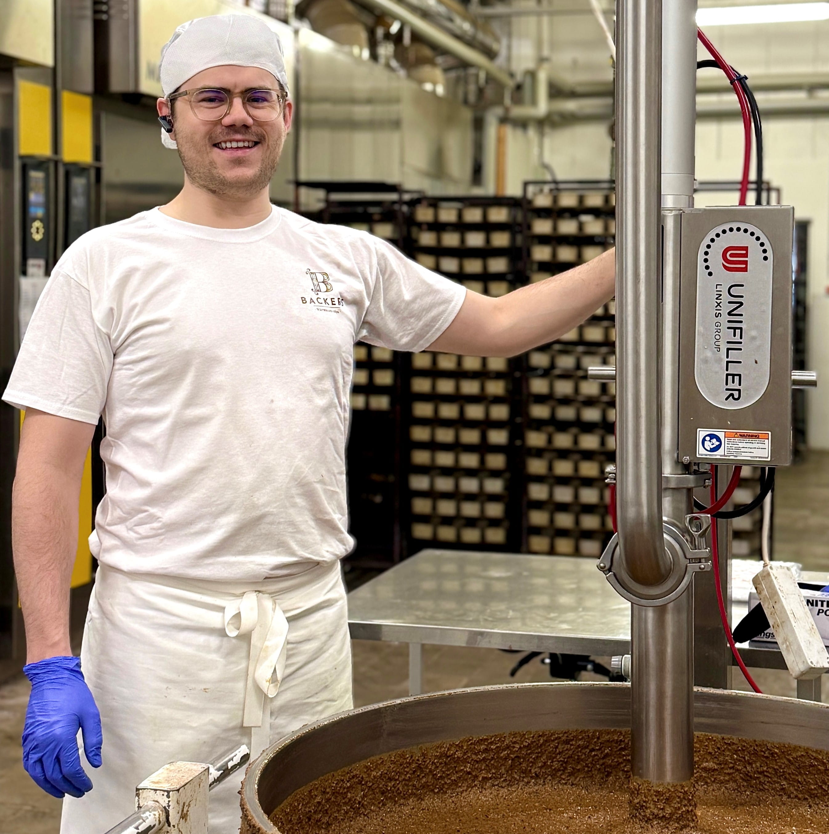 Gustaf Lindholm seisoo leipomolaitteeen vieressä